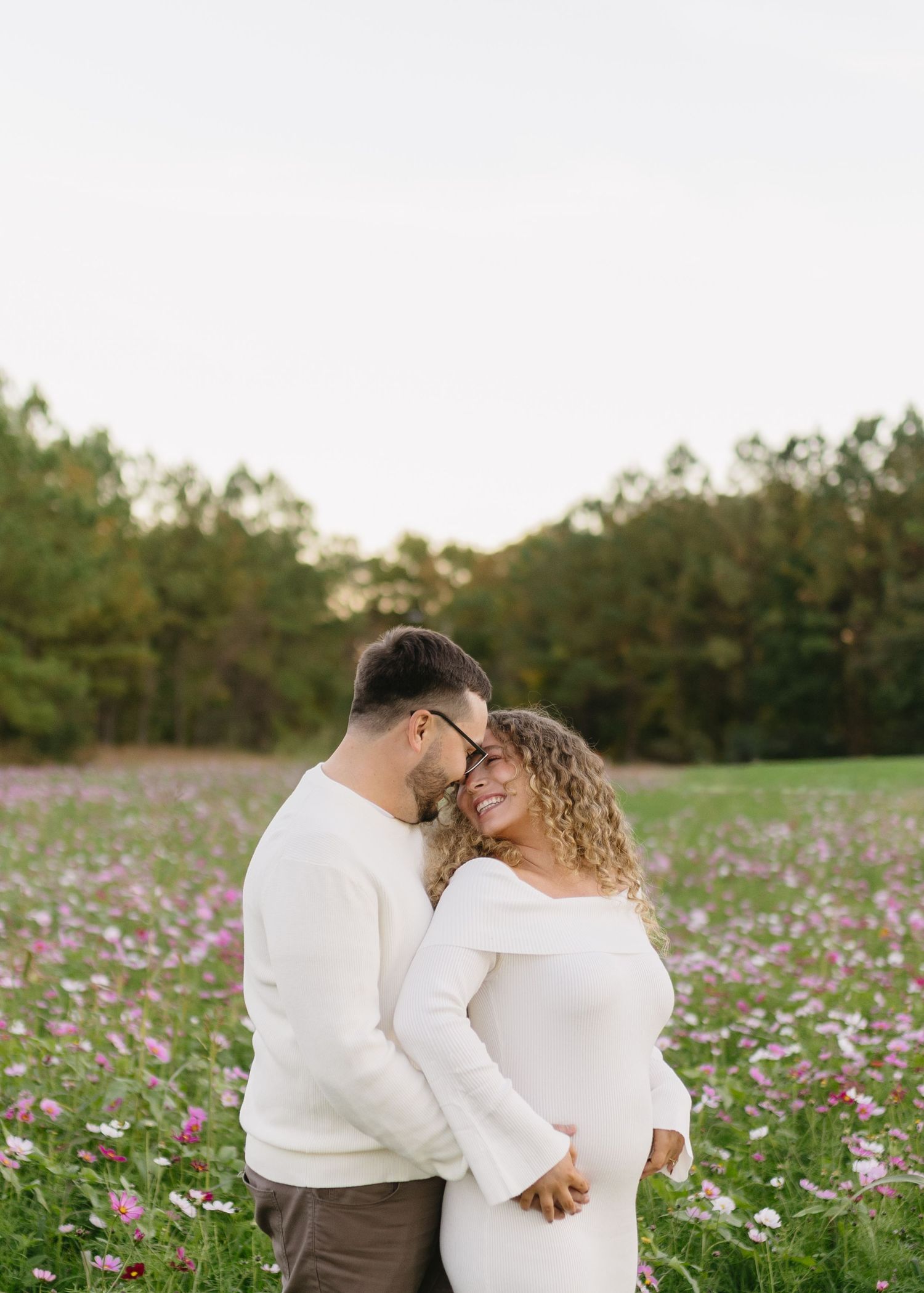 A couple sharing an intimate moment in a blooming wildflower field.