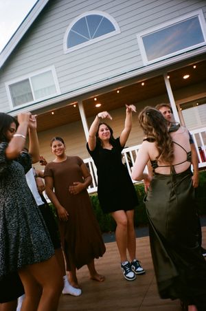 A group of people dancing and celebrating at what appears to be a casual indoor party or gathering.