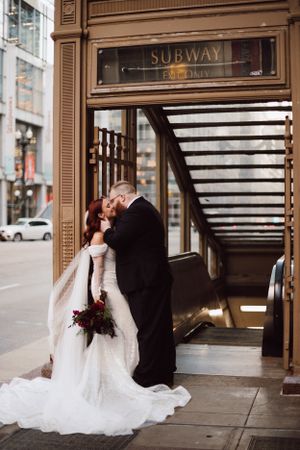 Urban wedding photos taken against classic architecture and subway entrance.