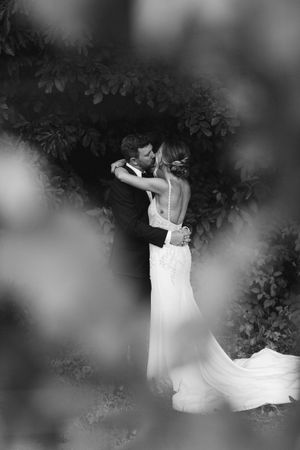 Romantic black and white wedding photos showing a flowing white dress against a dark background.