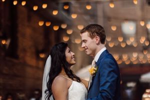 Romantic wedding portrait with warm bokeh lights creating magical atmosphere.