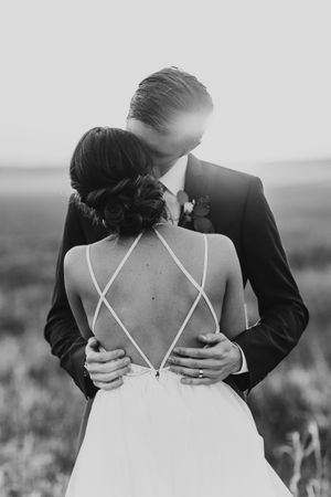 Black and white photo series showing details of a bride's crossed-back wedding dress.