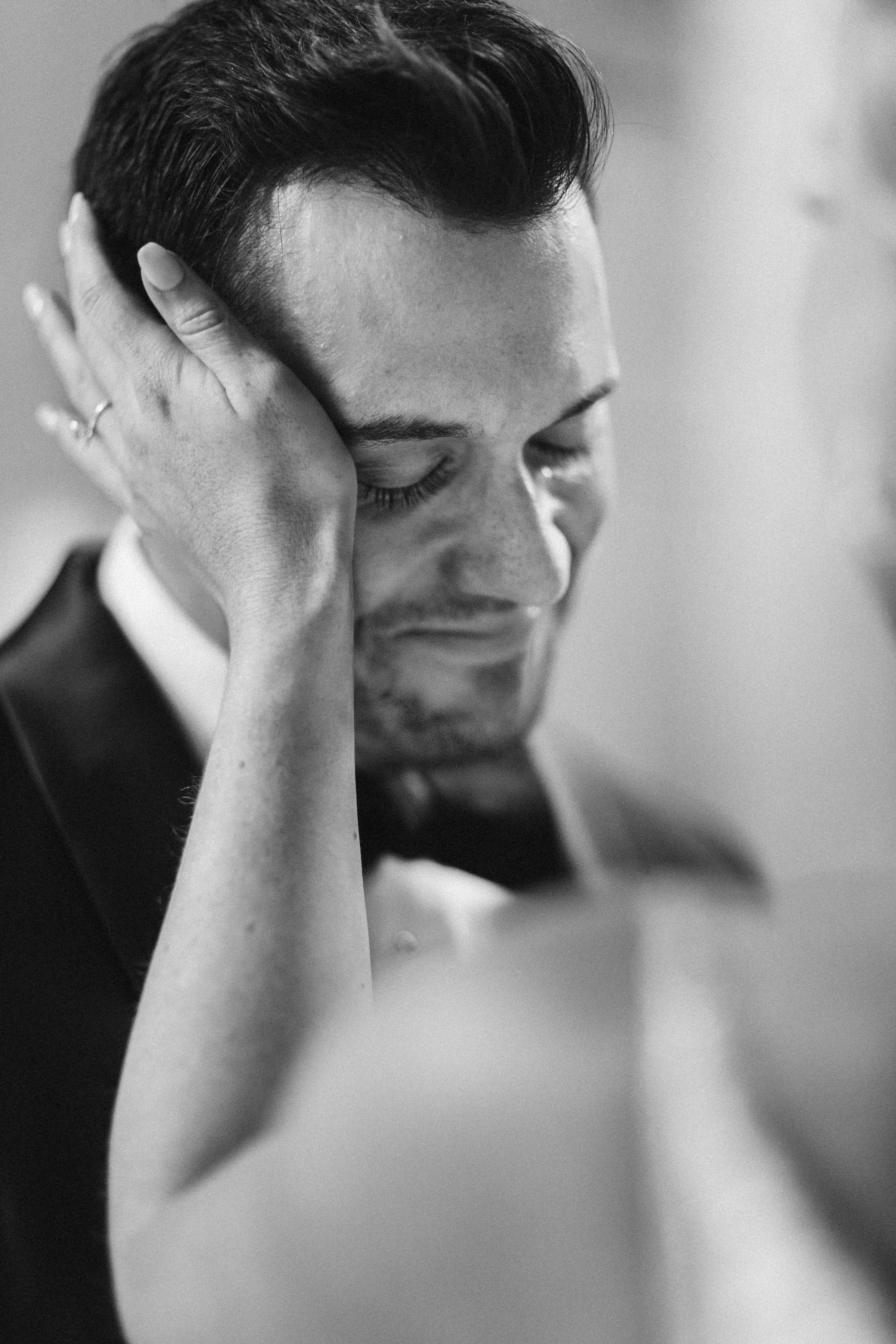Black and white close-up series showing emotional moments during wedding preparation.