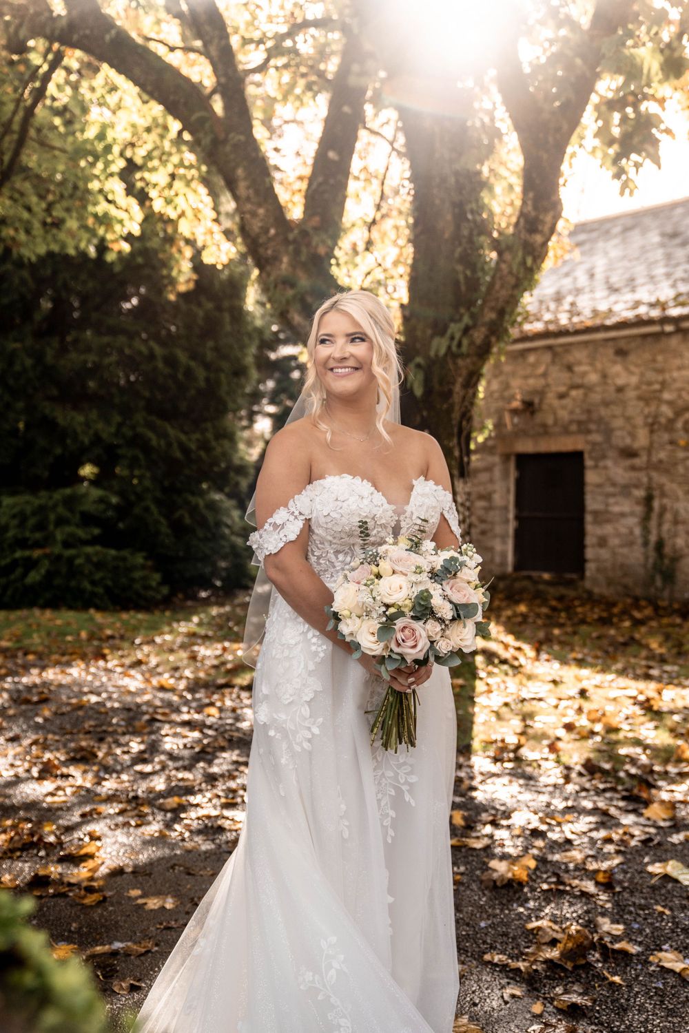 Autumn wedding photos featuring a bride holding a beautiful bouquet of blush and white flowers.