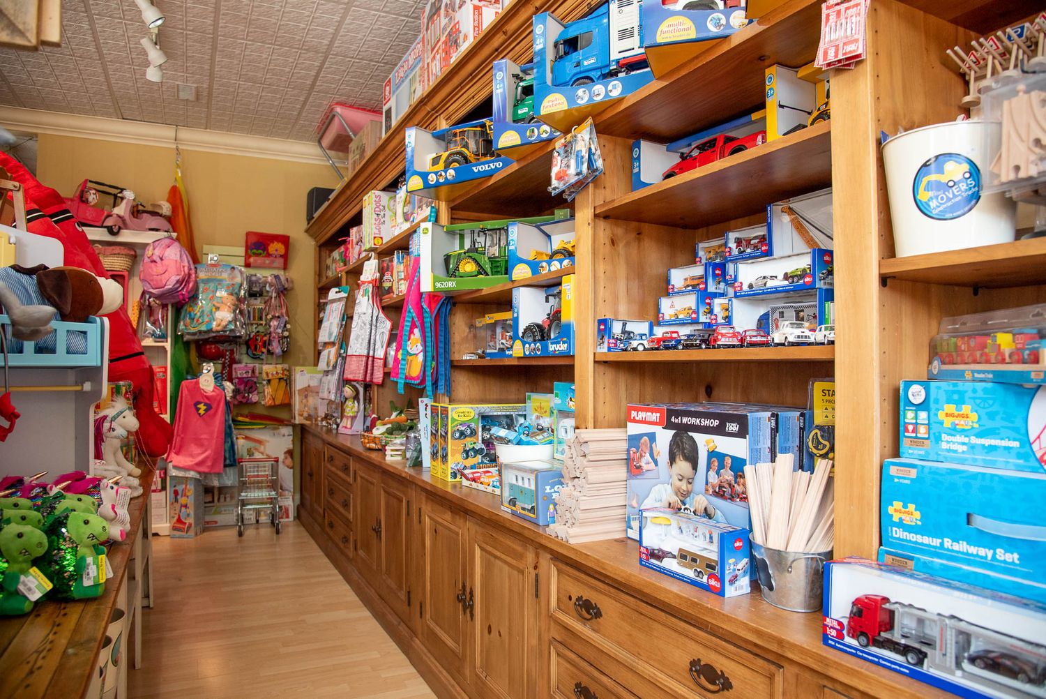 Interior view of a pharmacy store showing wooden shelving filled with medical supplies and healthcare products.