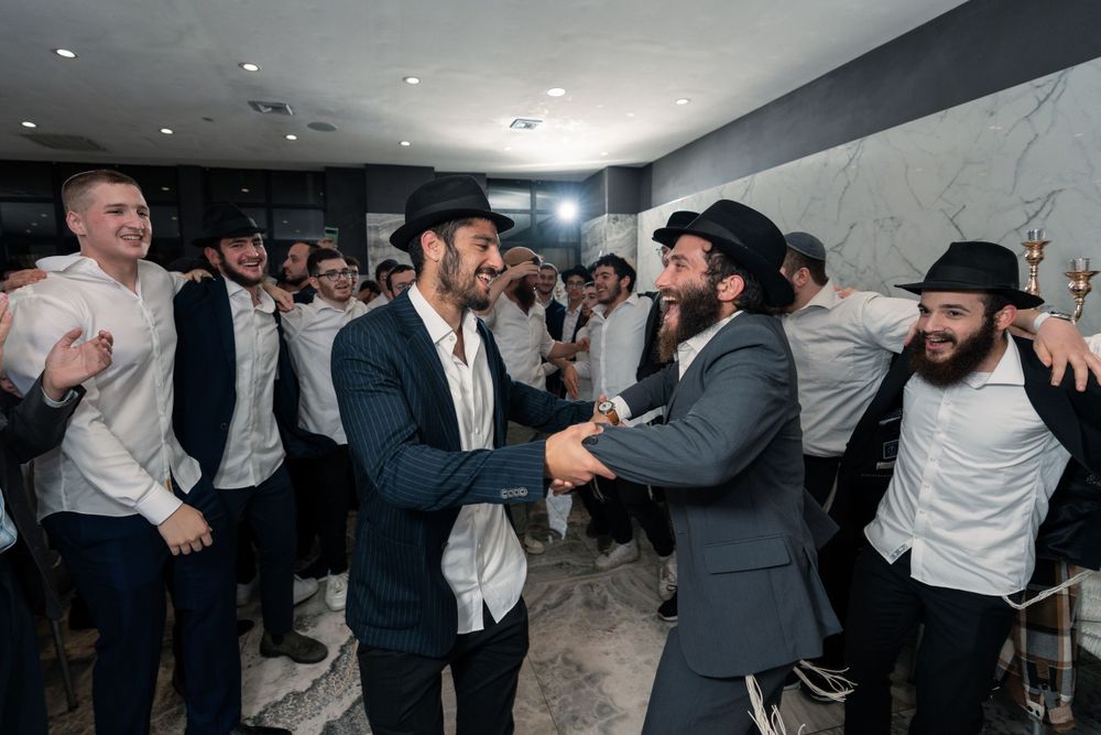 People dancing and celebrating at a traditional Jewish wedding reception.