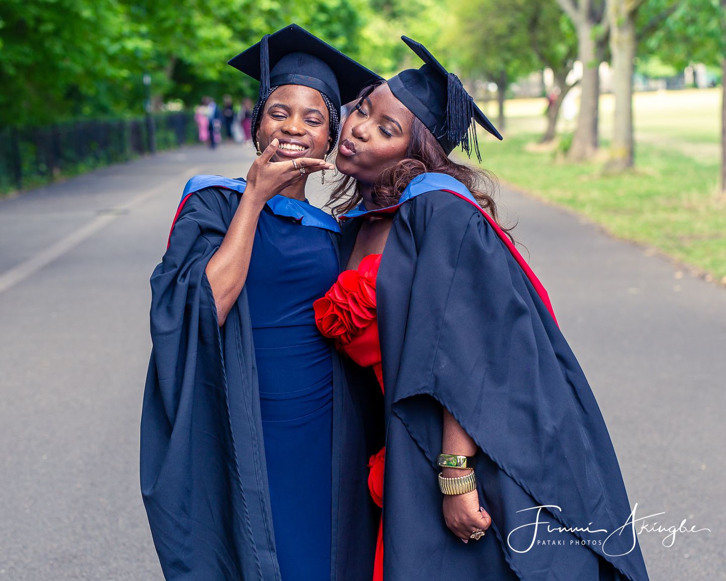 A graduation photo series showing a warm embrace between two ladies in their caps and gowns in a park setting.
