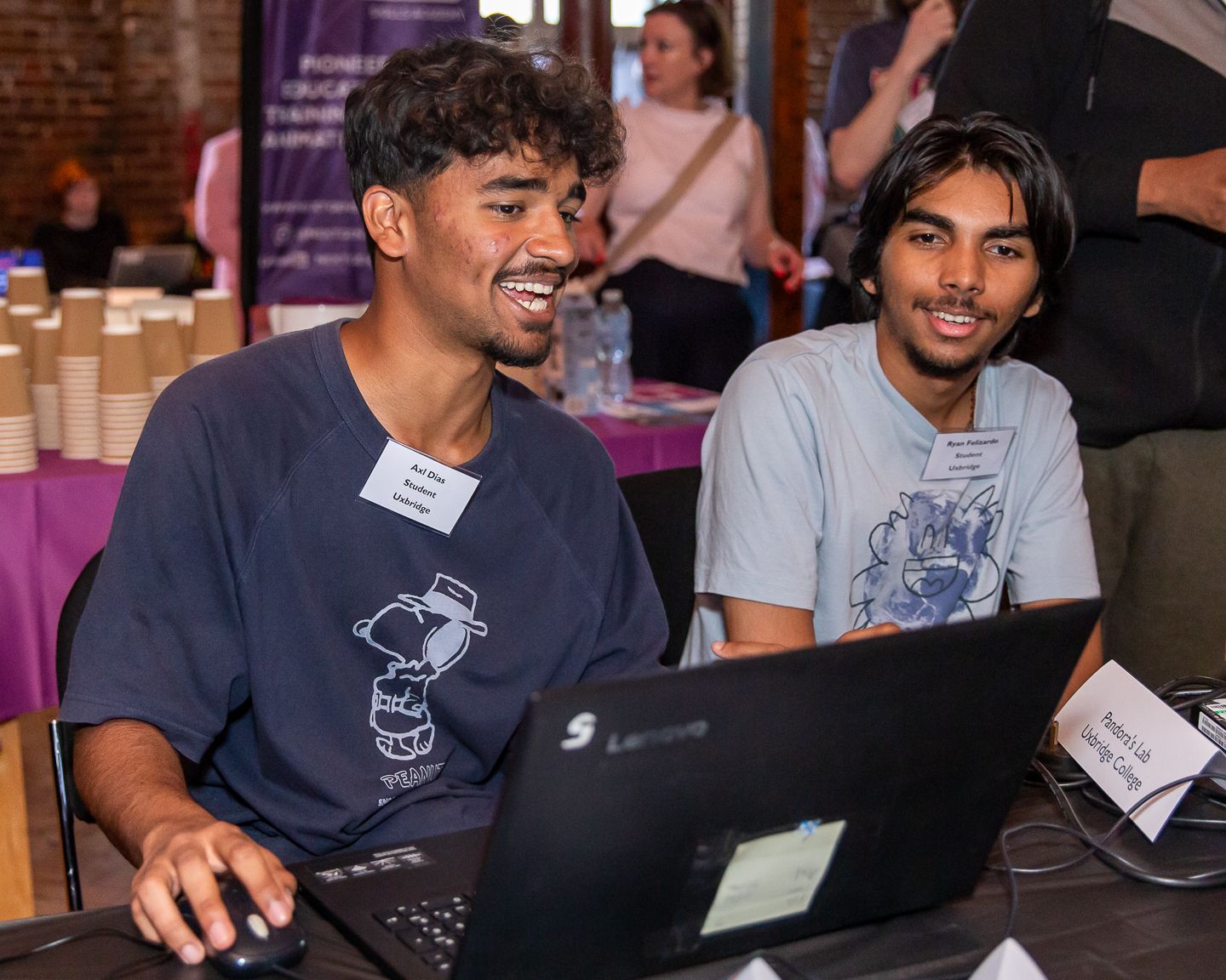 Guests at the NextGen skills academy graduate showcase event held in London, playing a video game designed by one of the students