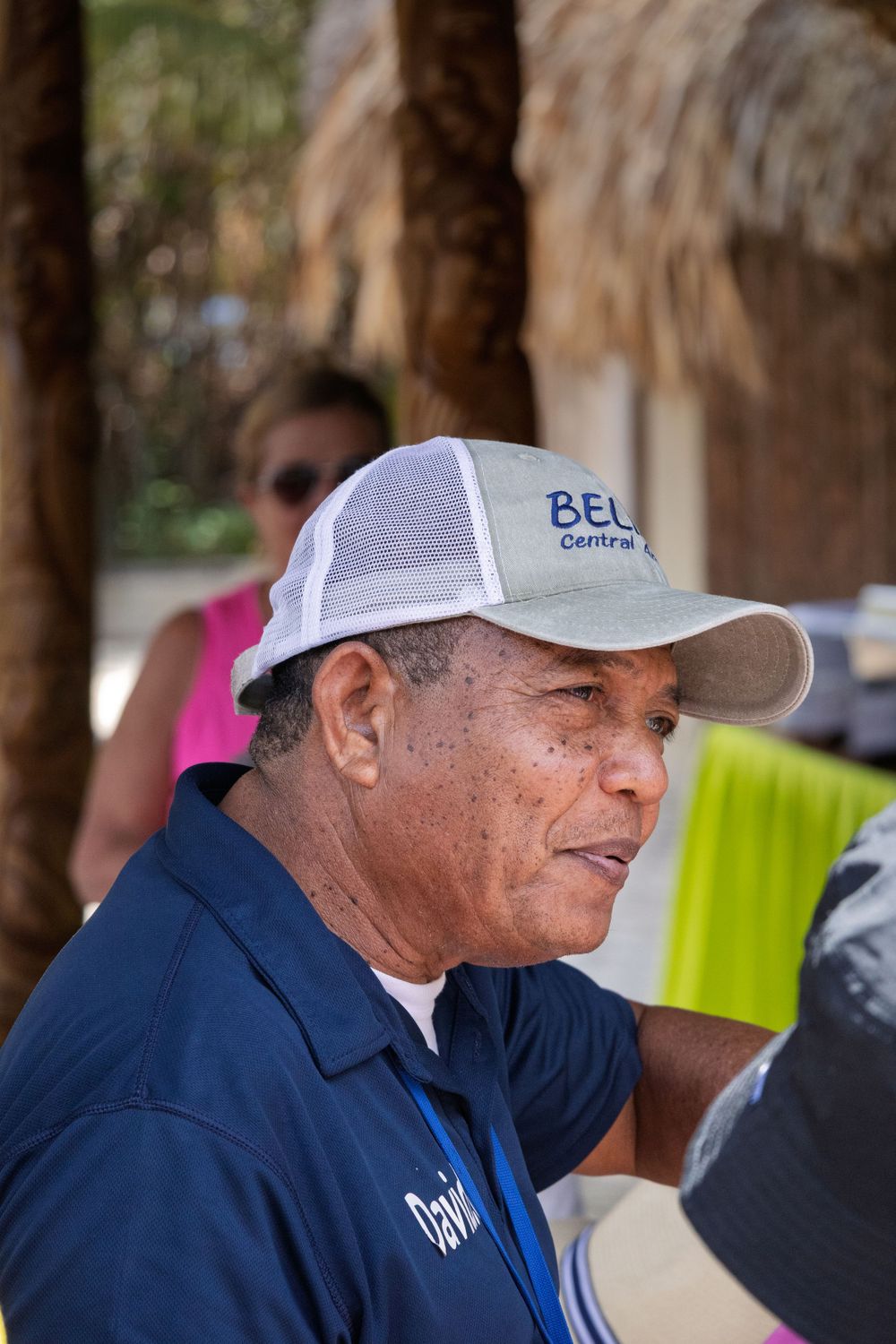 Person wearing a blue shirt and baseball cap at an outdoor event.