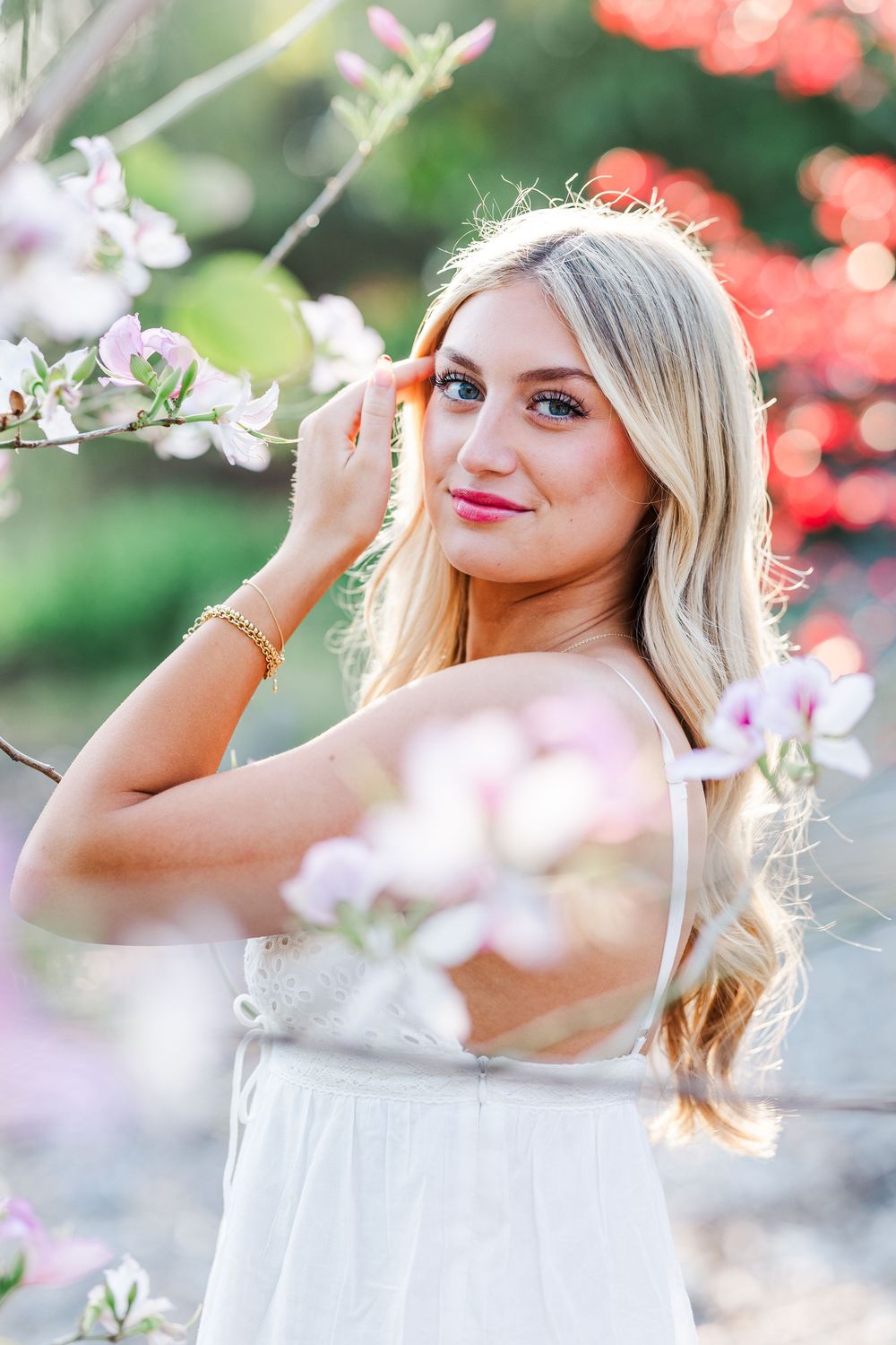 Ethereal springtime portrait surrounded by delicate cherry blossoms and soft bokeh lighting effects.