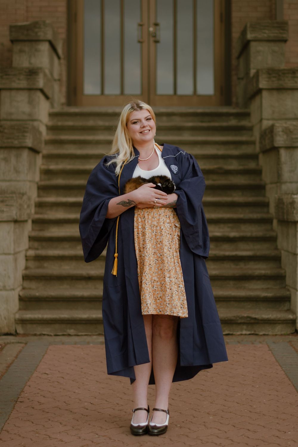 A college graduate in gown holding her guinea pig in Spokane, Washington.