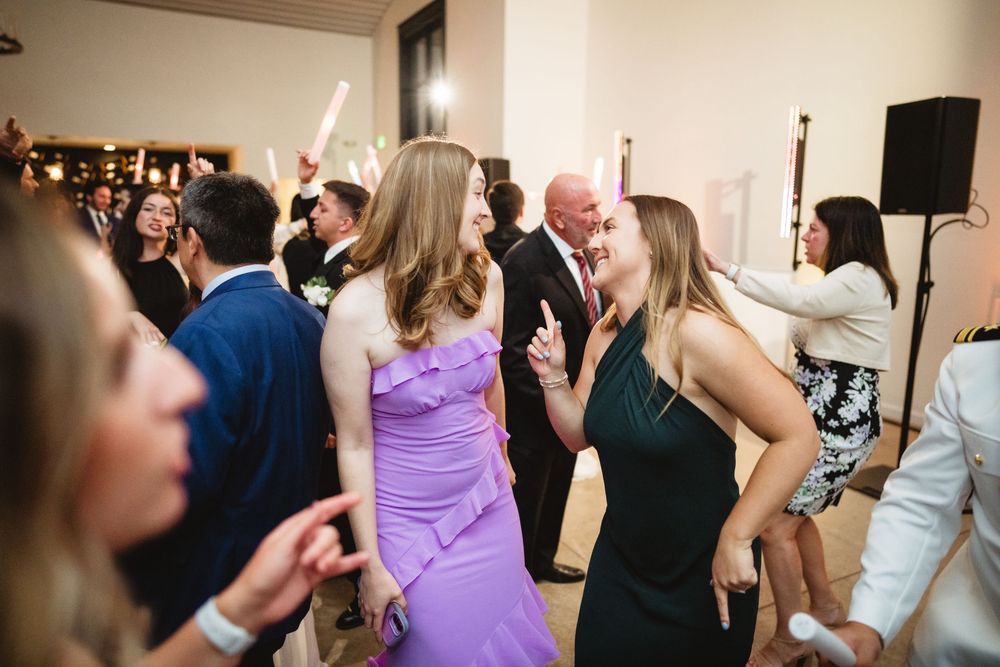 A lively dance party scene with people enjoying themselves on the dance floor at a festive indoor celebration.