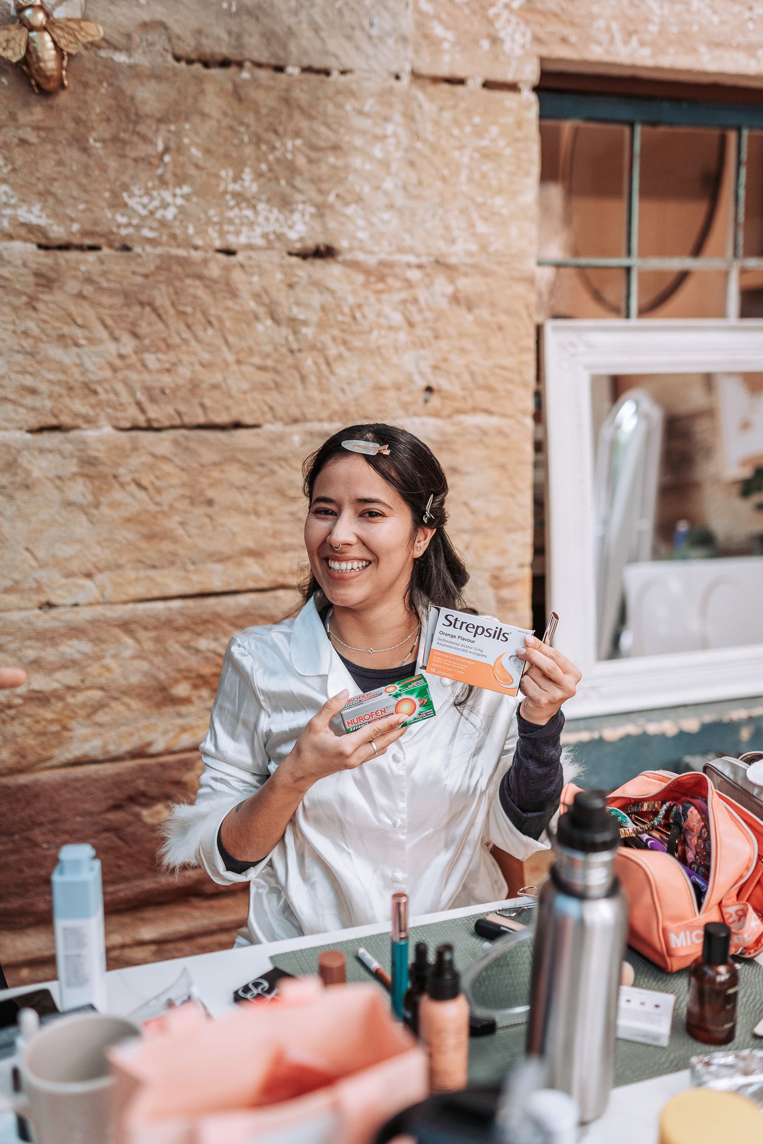 Someone displays a protein bar near a table with drinks and outdoor equipment in a rustic setting.