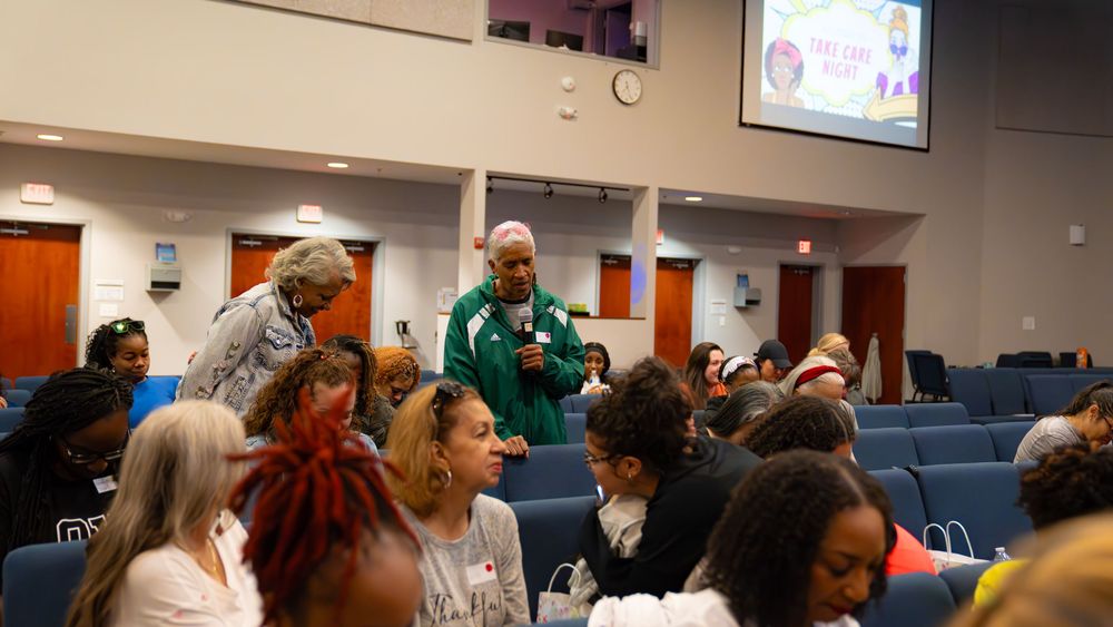 Audience members engage during presentation in modern lecture hall setting.