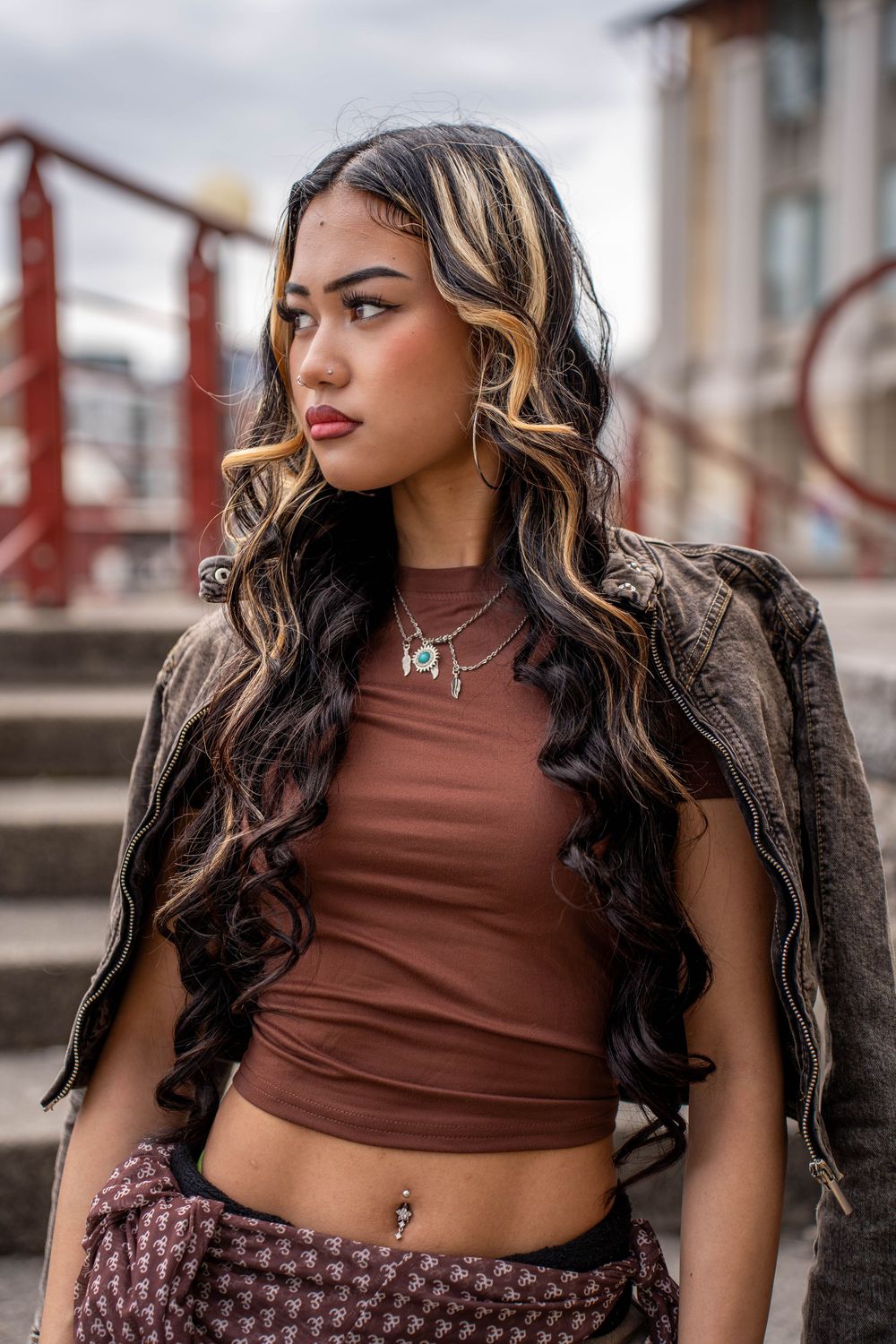 Fashion portrait featuring brown crop top and leather jacket with styled hair.
