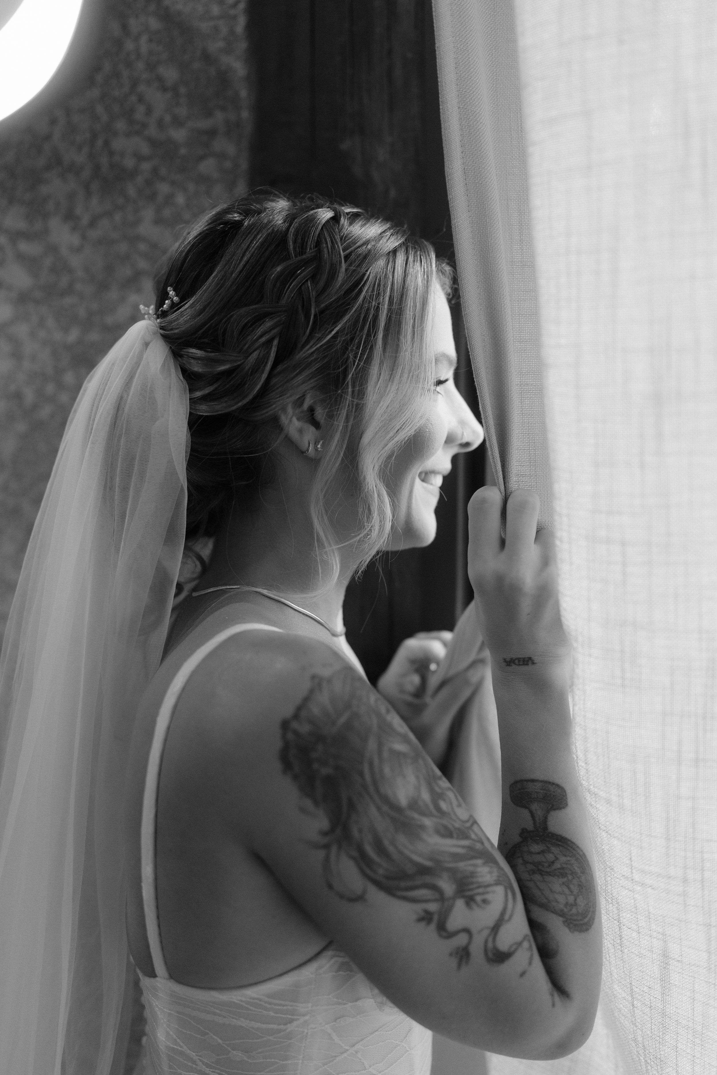 Black and white artistic portrait with sheer curtains creating a dreamy atmosphere.
