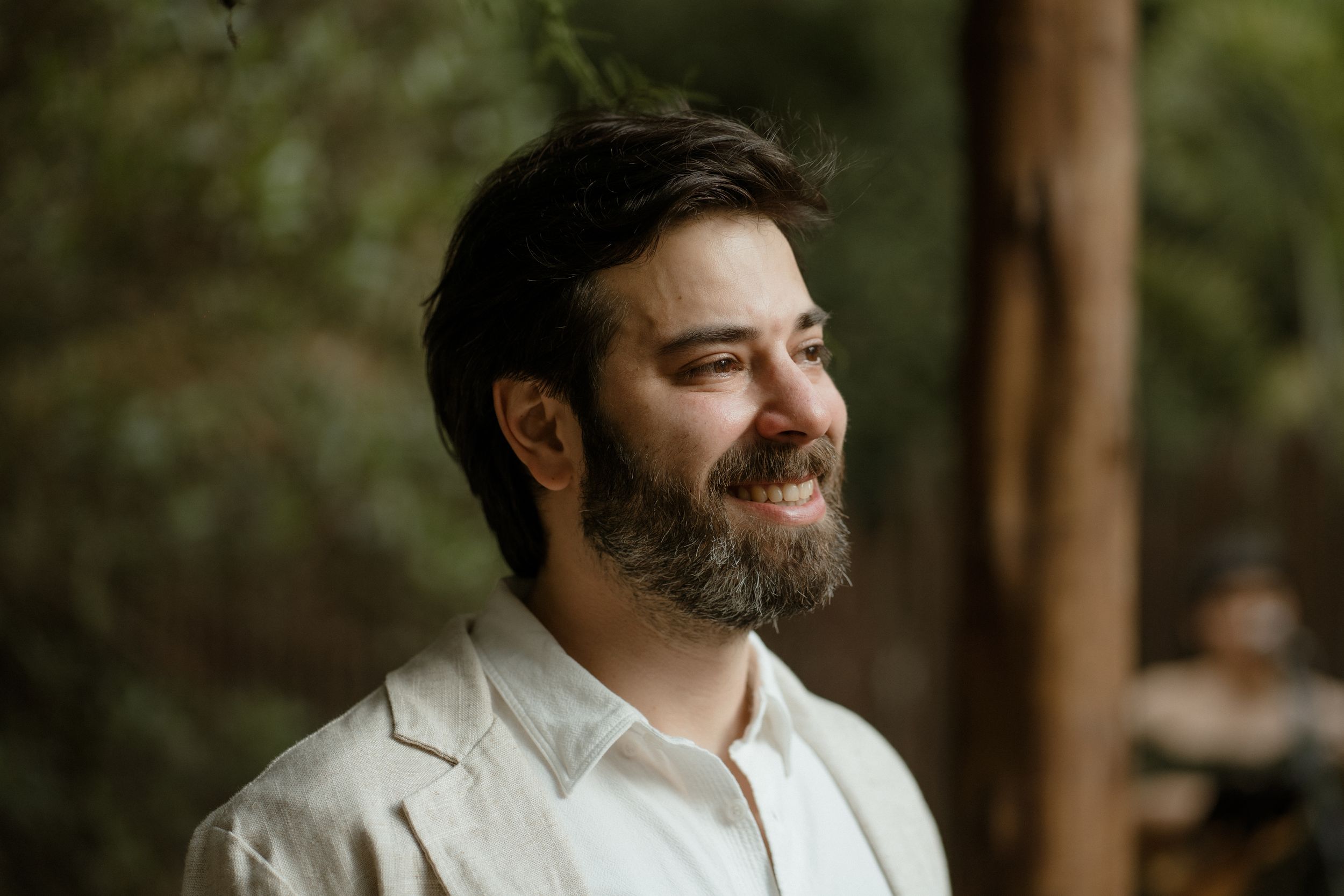 A warm rustic portrait taken outdoors with soft natural lighting and greenery in the background.