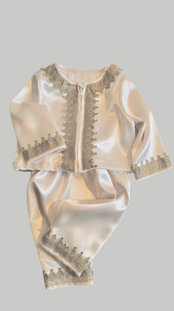 Elegant cream-colored silk baby outfit with delicate gold lace trim details on jacket and pants.