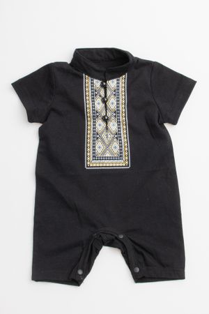 Black baby romper with decorative embroidered bib panel featuring geometric patterns in white and blue embellishments.