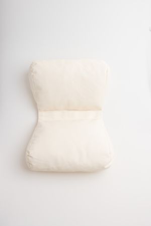 Simple white hourglass-shaped cushion photographed on a white background.