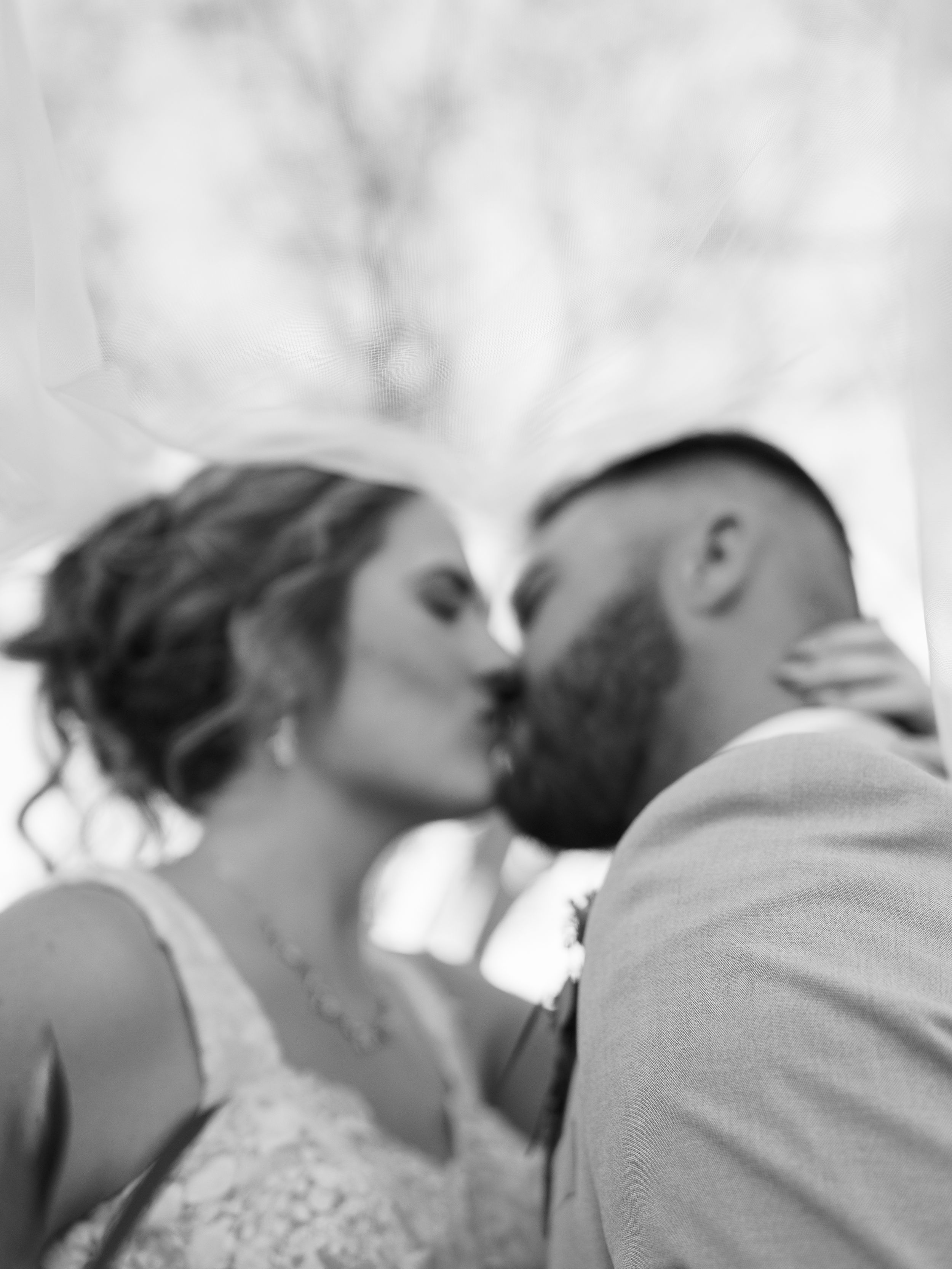 A series of black and white photographs showing intimate romantic moments between a couple in wedding attire.