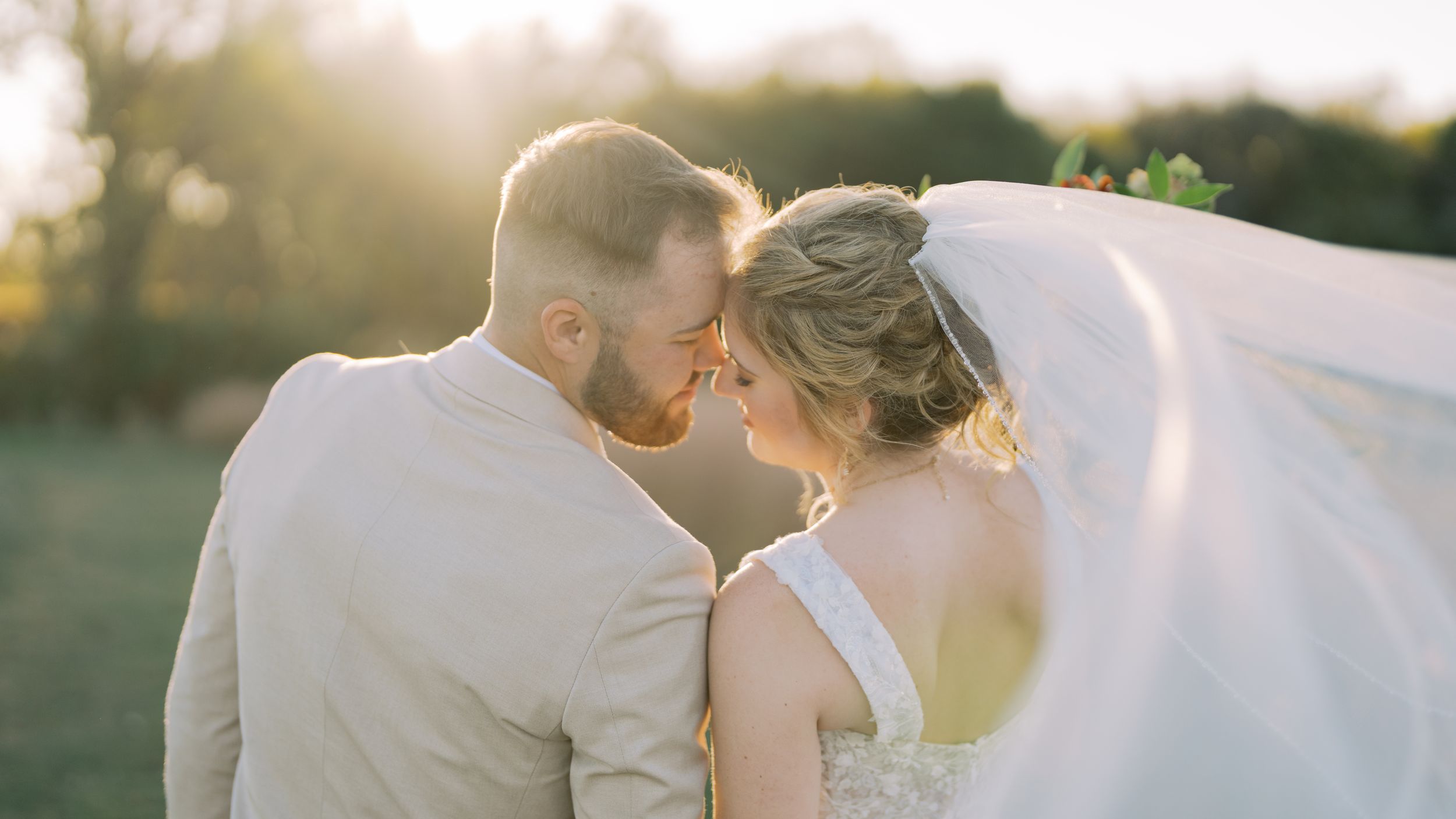A romantic wedding couple embraces in a series of intimate outdoor portraits during golden hour.