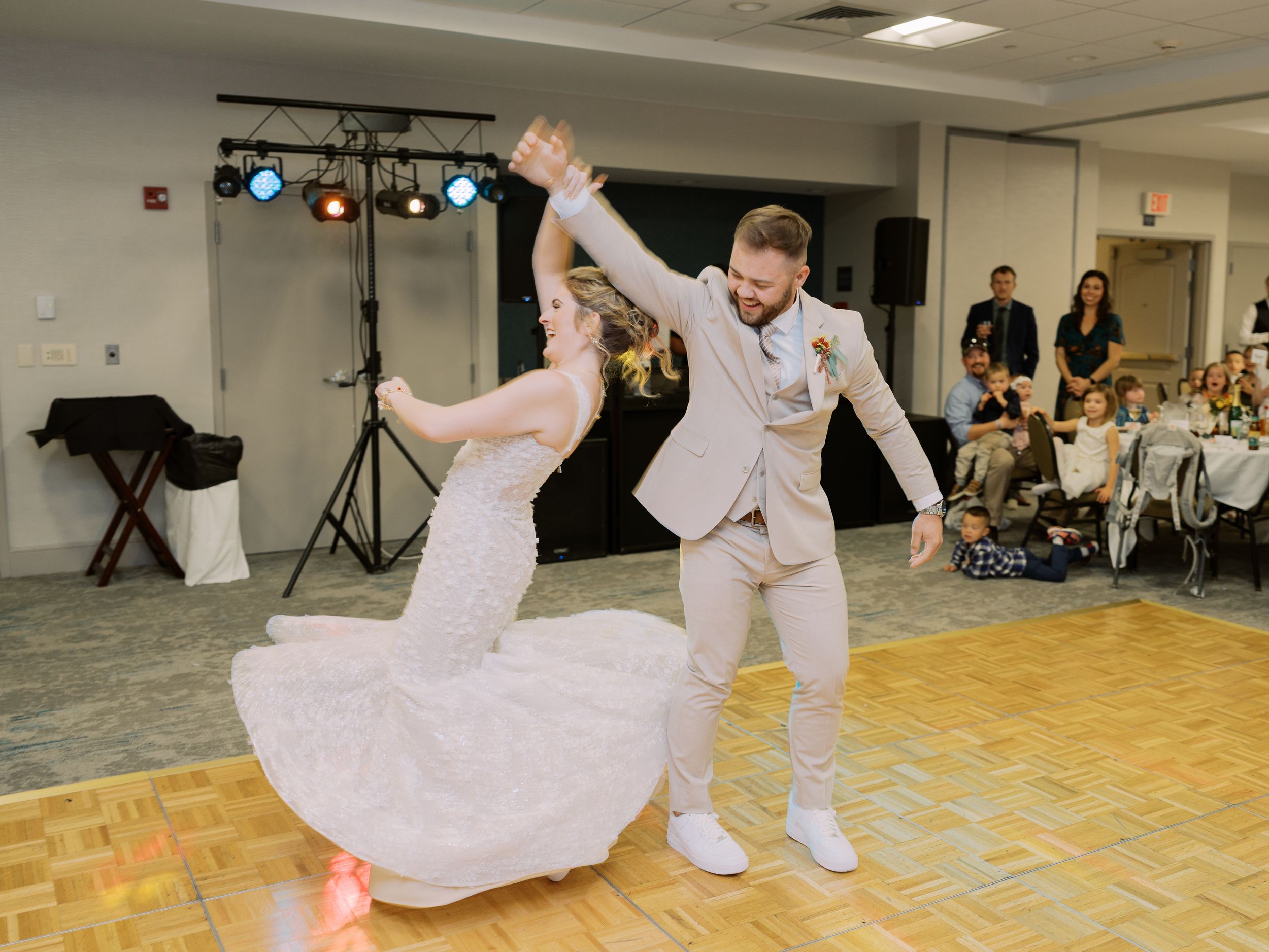 A series of dance moves being performed on a parquet floor in a studio with lighting equipment visible in the background.