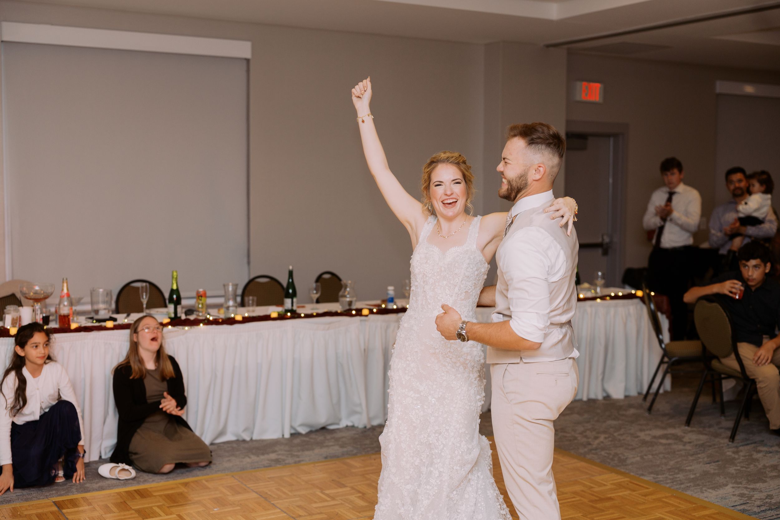 Four connected photos show people dancing and celebrating at a wedding reception in a white-decorated banquet hall.