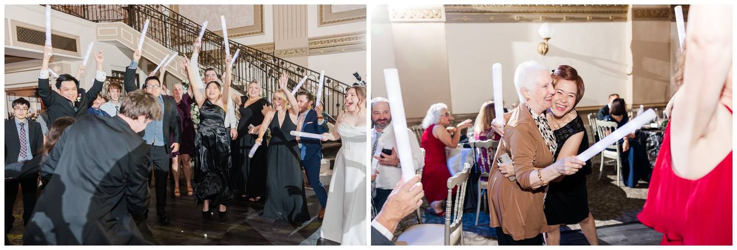 Wedding reception guests celebrate and dance together in a spacious indoor venue.