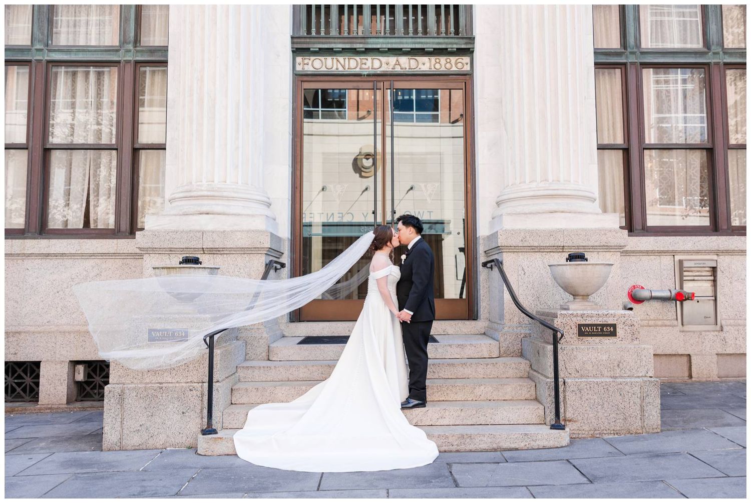 Wedding portraits against classic stone architecture with elegant white dress and veil.