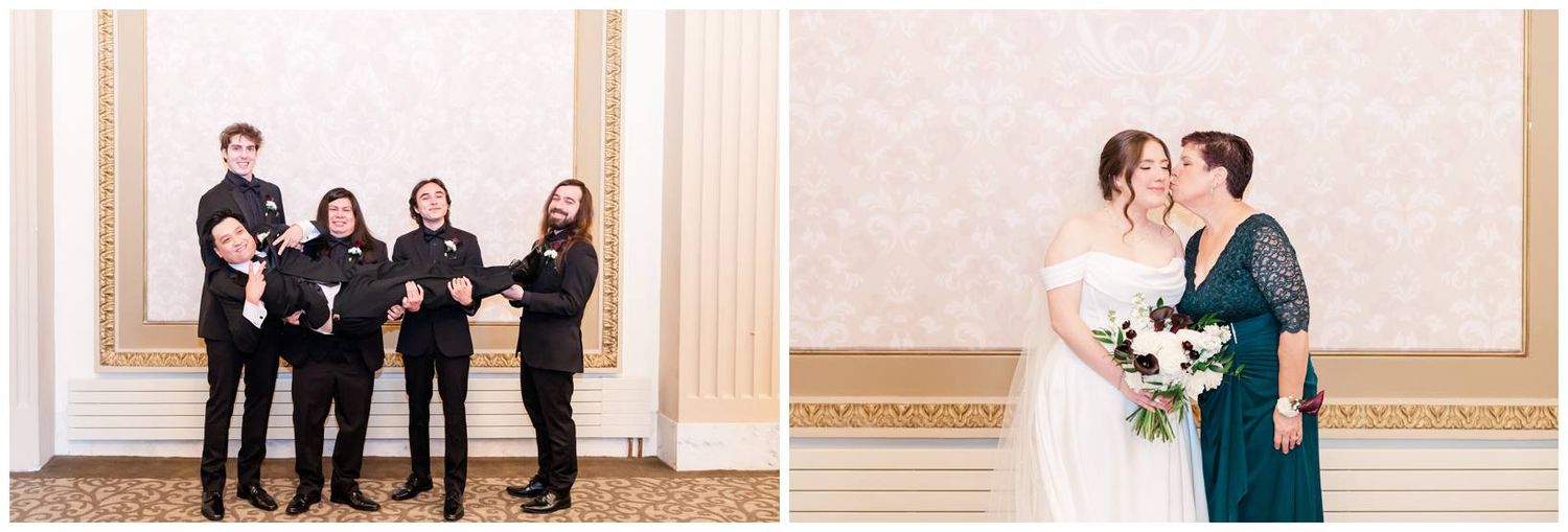 Wedding party members gather in formal attire against cream-colored walls of an elegant venue.