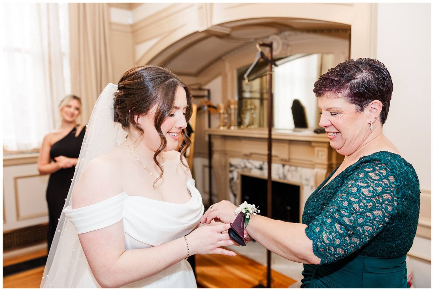 Wedding party members share joyful moments during formal photos in an elegant venue with ornate decor.