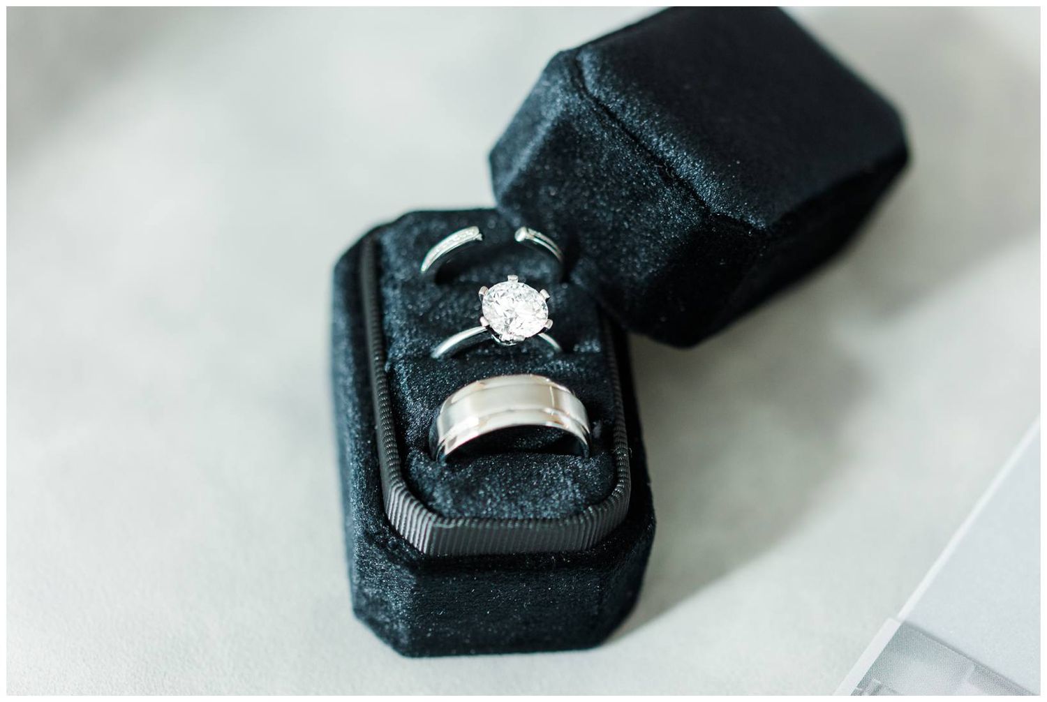 Close-up photos of diamond engagement rings in black velvet jewelry boxes on white background.