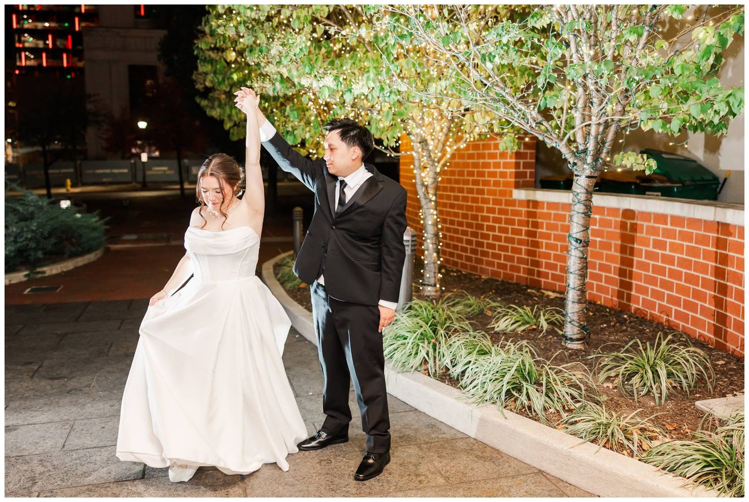 Outdoor wedding photography session with red brick walls and garden landscaping elements.