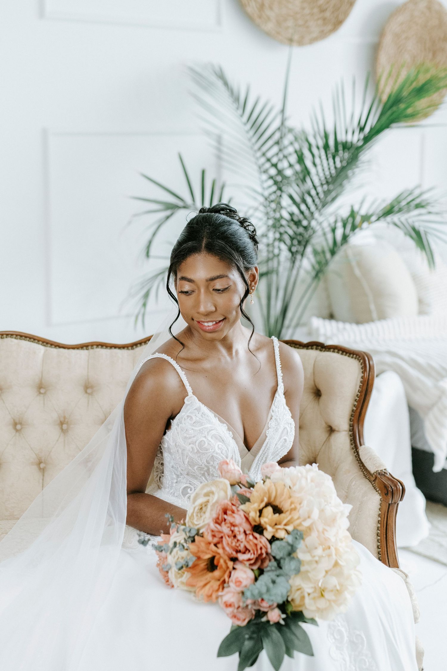 Elegant bridal portrait series featuring a white lace wedding dress and peach-toned floral bouquet in a bright studio setting.
