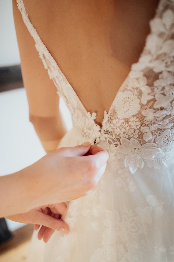 Detailed close-up of intricate white lace pattern on a wedding dress bodice.