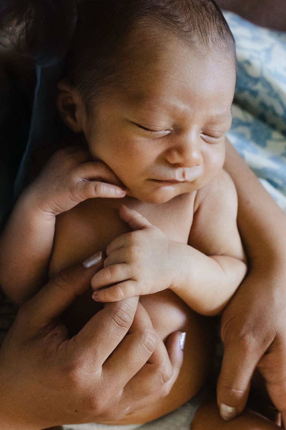 A sequence of images showing a baby's tiny hand grasping and exploring an adult's finger in close-up detail.