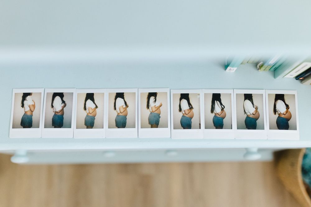 A row of instant photo strips showing different poses and expressions displayed on a white surface.