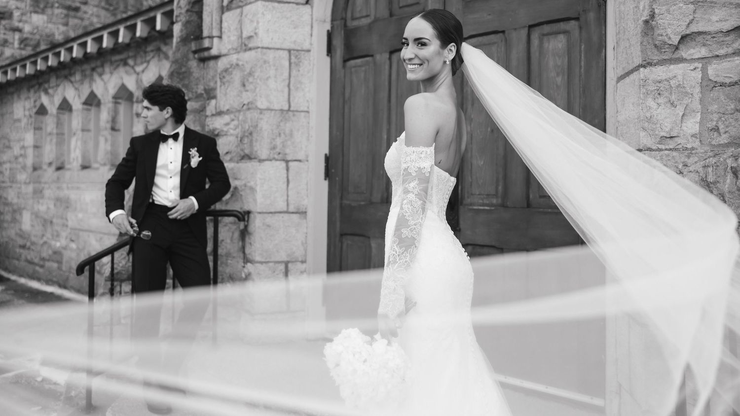 A wedding couple dances together during their first dance in an elegant stone venue.