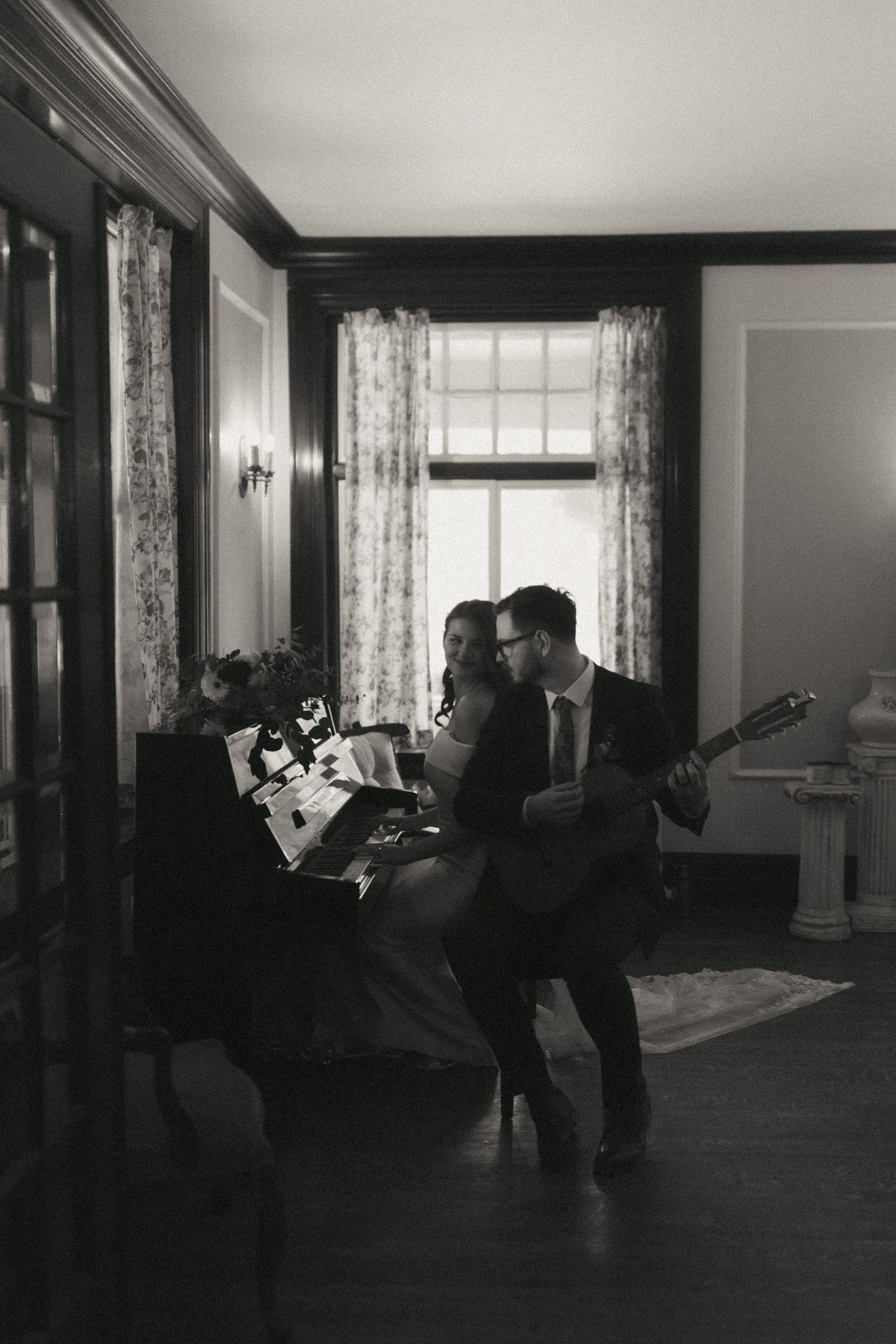 Dramatic black and white photo sequence showing figures dancing in an elegant room with large windows and curtains.