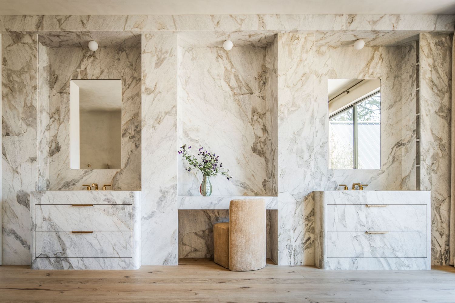 Interior view of an abandoned marble quarry with white stone walls and pillars creating a stark architectural space.