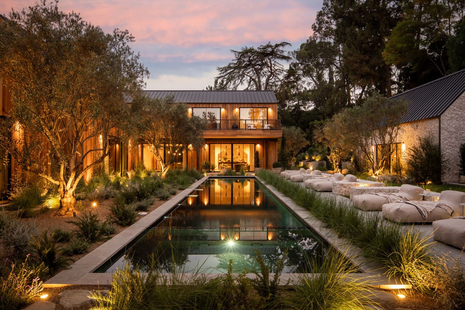 Modern luxury villa with infinity pool illuminated at dusk showcases seamless indoor-outdoor living design.