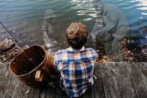A sequence of photos showing someone in a plaid shirt sitting on a log by a river while fishing.