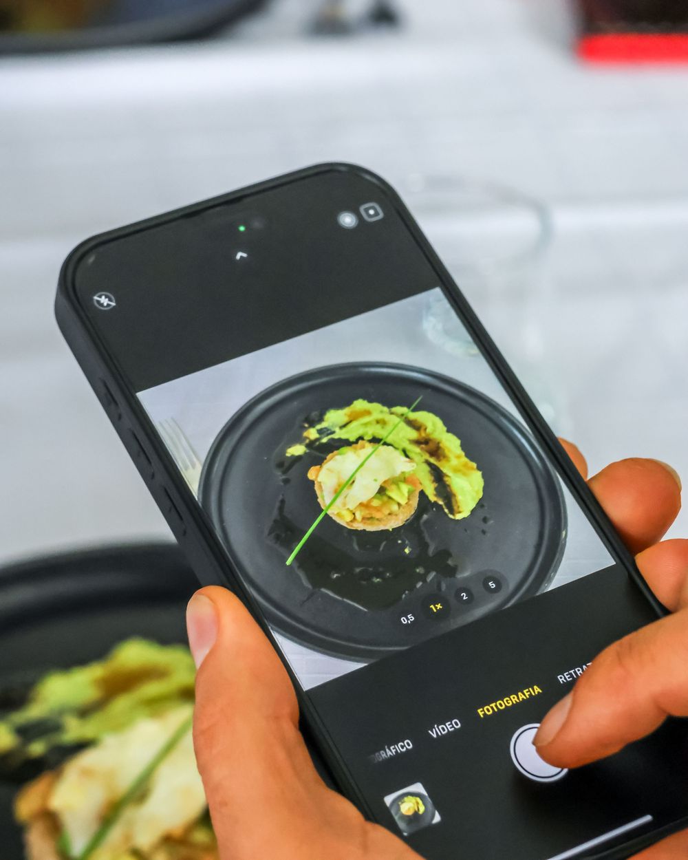 Close-up sequence showing someone taking photos of food on a smartphone camera.