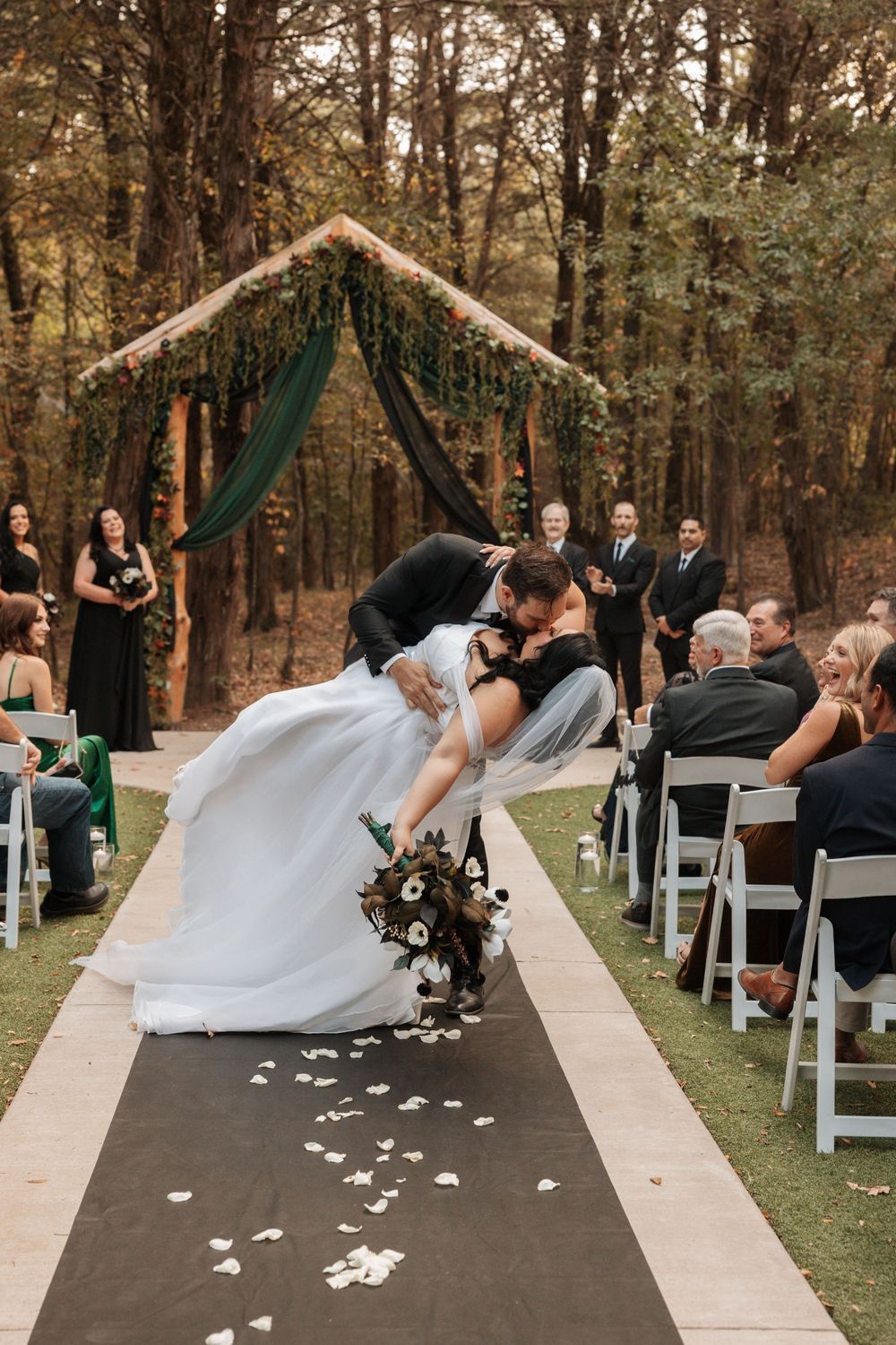 A sequence of wedding ceremony photos showing flower petals being thrown along a dark aisle runner in an outdoor forest setting.