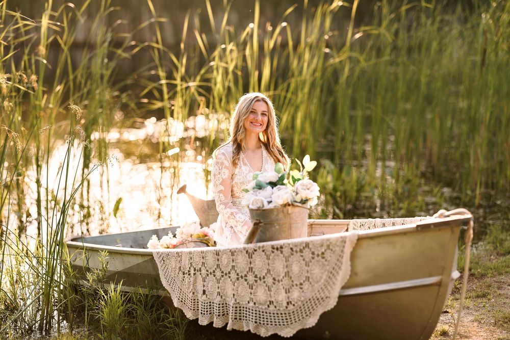 Romantic scene with lace-draped boat on lake at sunset with flowers.