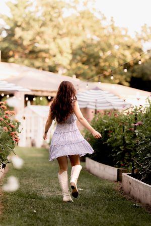 Whimsical garden photoshoot with flowing dress and soft evening light.