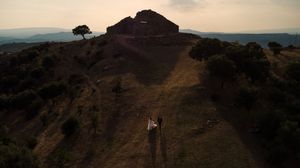 Panoramic sunset view of mountains and hills in warm golden light.