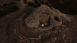 Aerial view of winding mountain paths and rocky terrain at dusk.