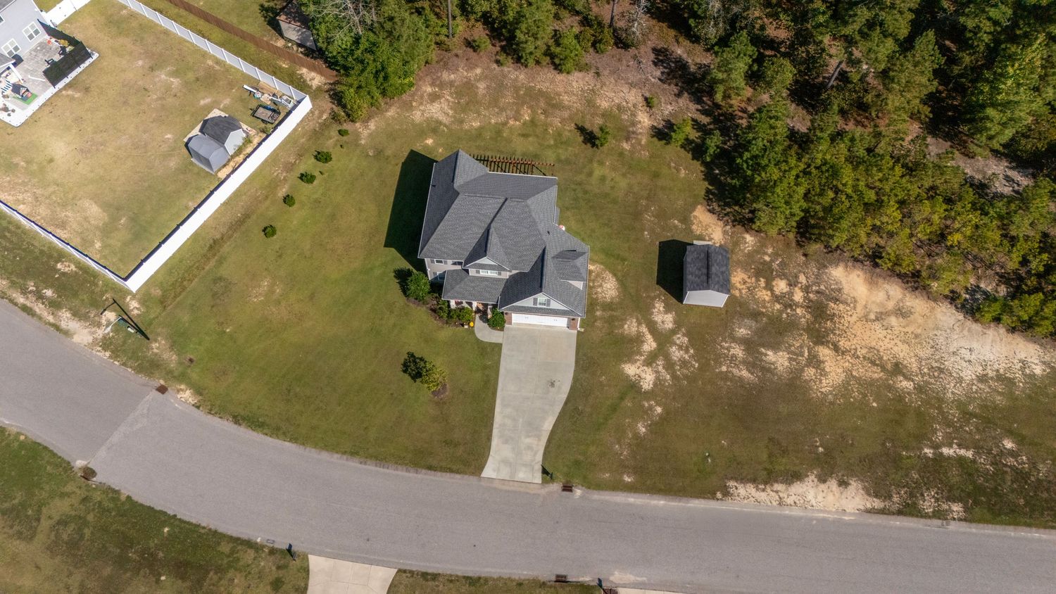 Aerial view of suburban neighborhood showing residential homes and tree-lined streets.